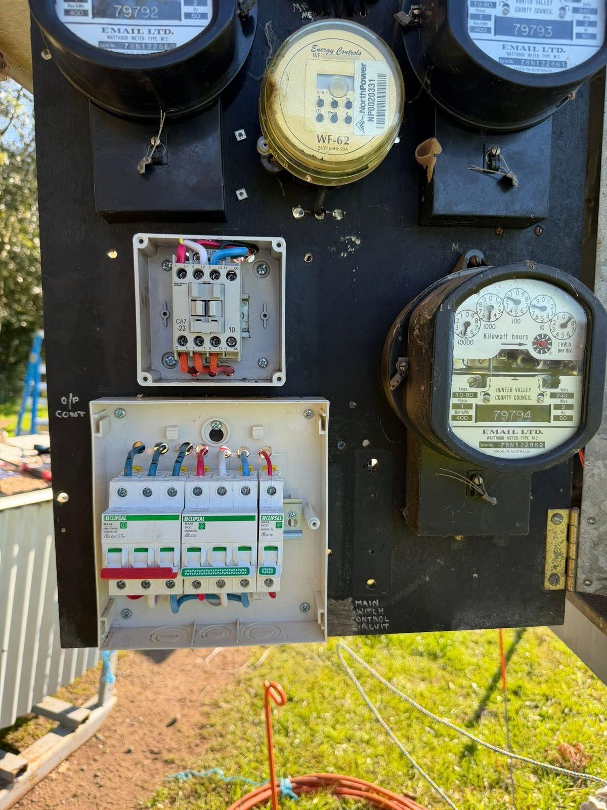 Meter panel with new circuit breakers and a contactor alongside the original meters