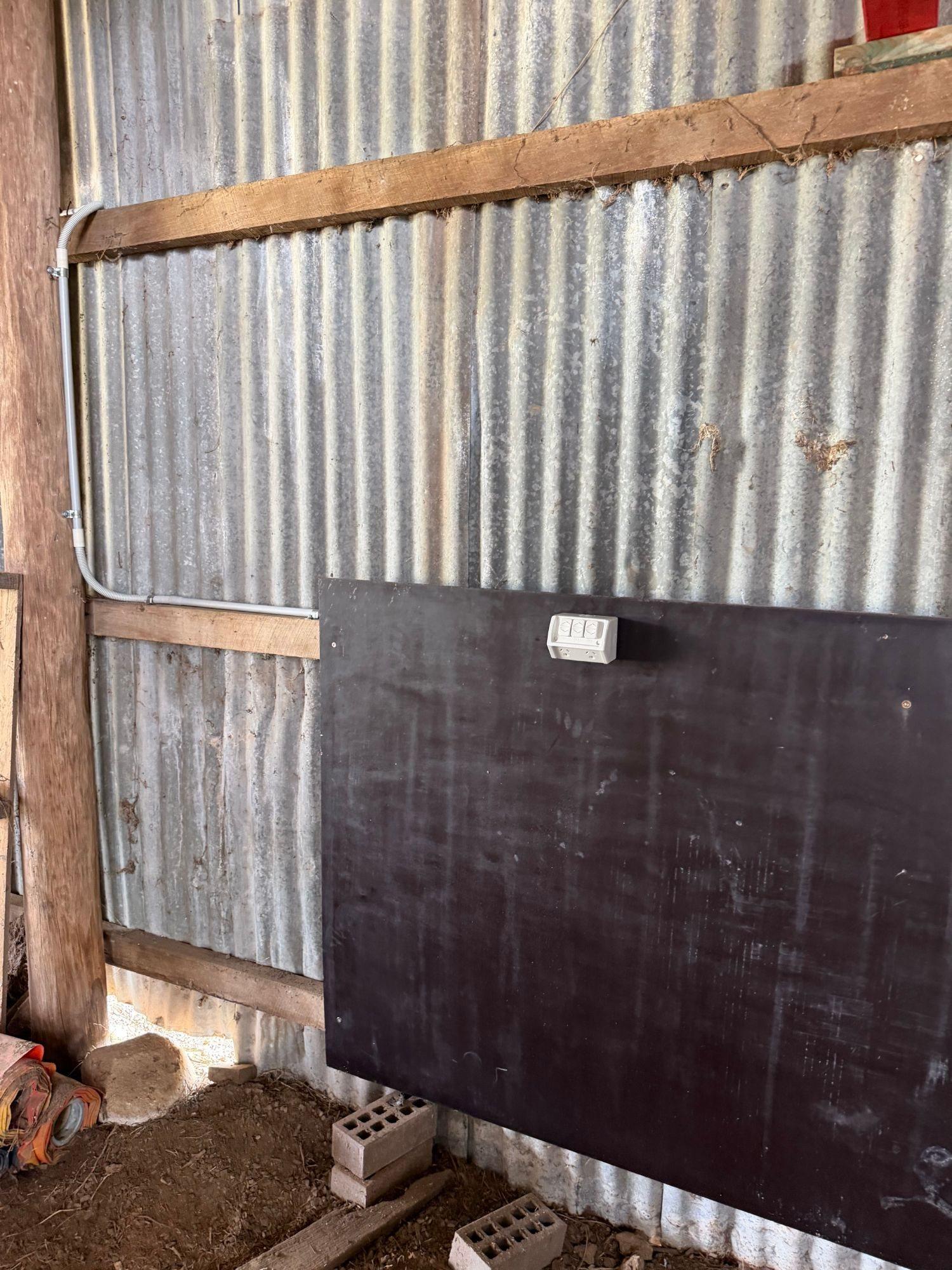 Double power point on a shed wall, fed by conduit run down from the beam above